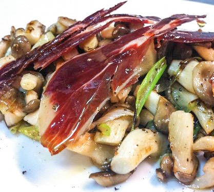 Setas salteadas con ajetes tiernos y jamón ibérico